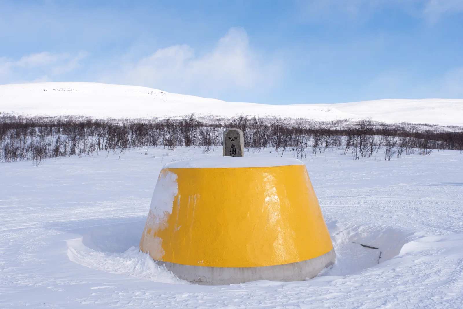 Snowmobile Safari — A yellow landmark surrounded by snow during the Kilpisjärvi safari