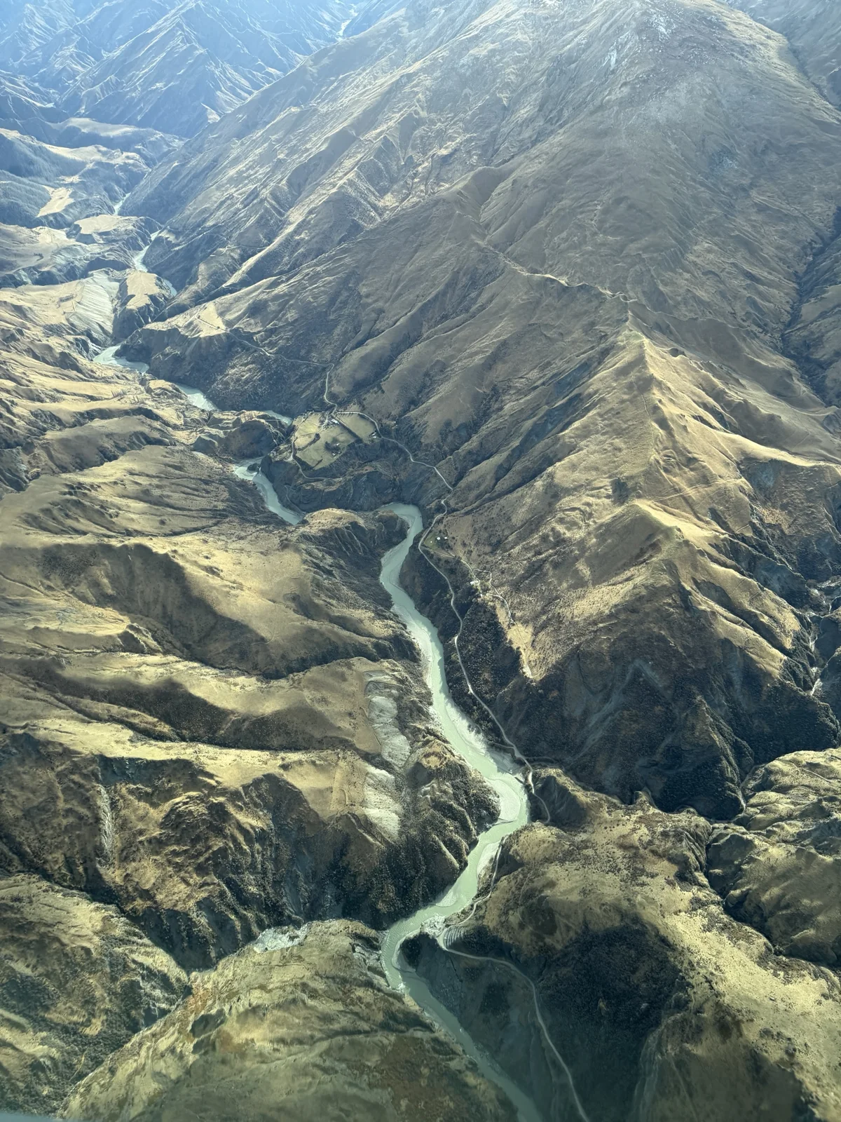 Milford Sound Flight & Cruise — A river winding through a mountain valley seen during the scenic flight