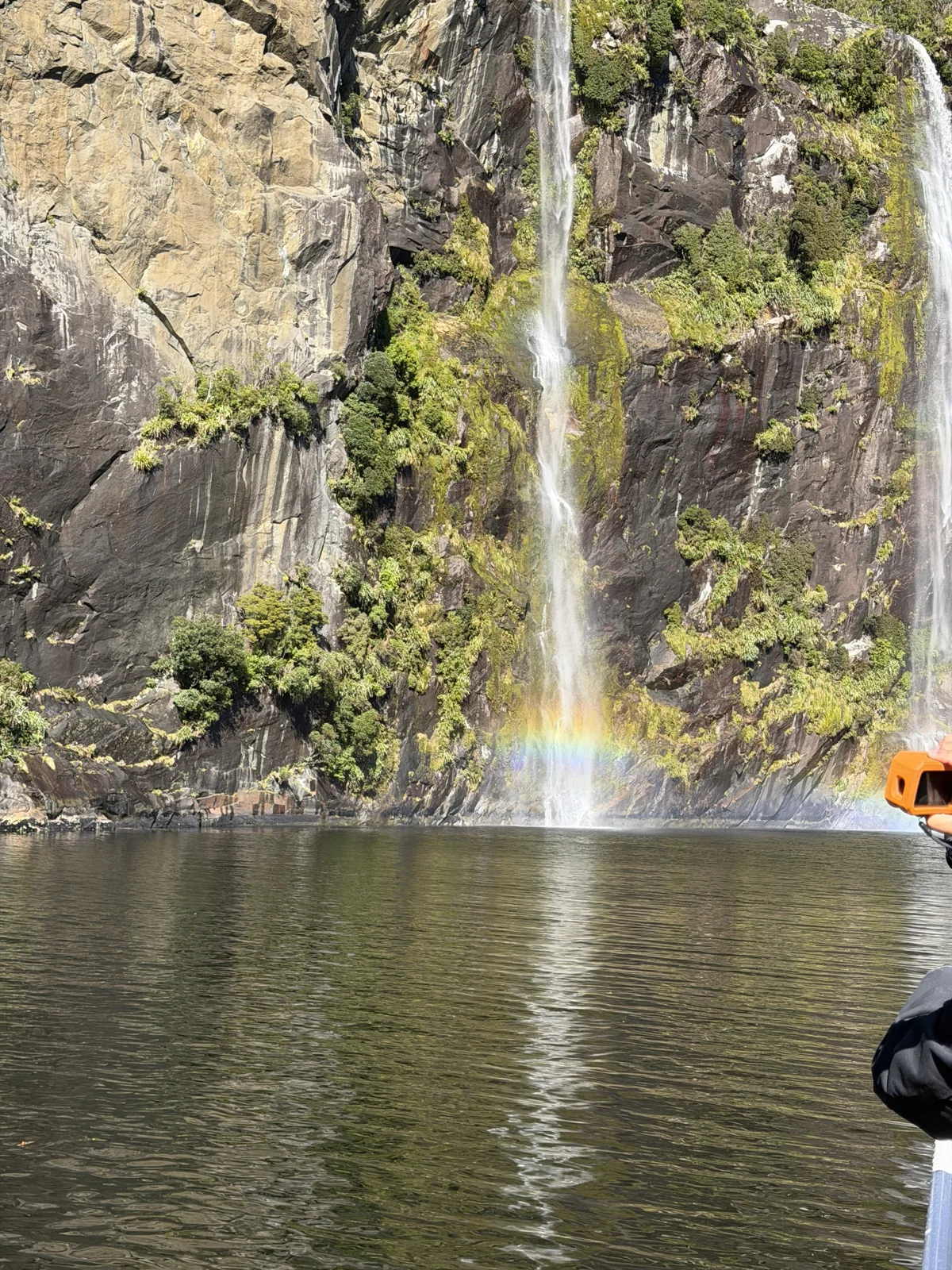 Milford Sound Flight & Cruise — A rainbow in waterfall spray viewed during the Milford Sound cruise